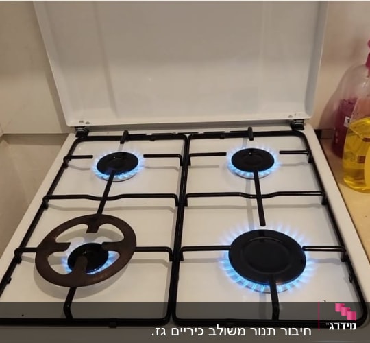 כיריים גז עם ארבעה מבערים דולקים
